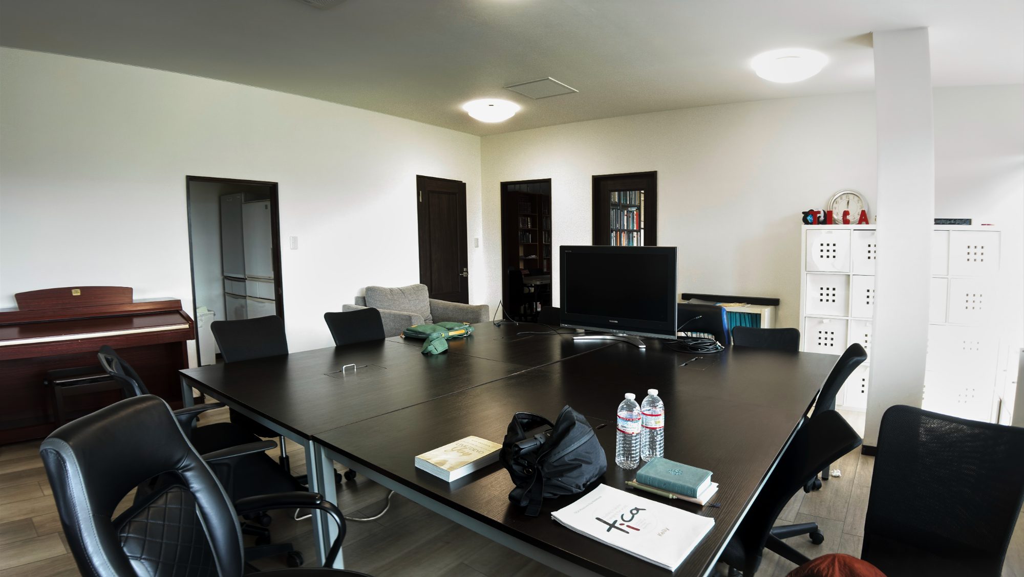 A small office with desks, chairs, and a whiteboard