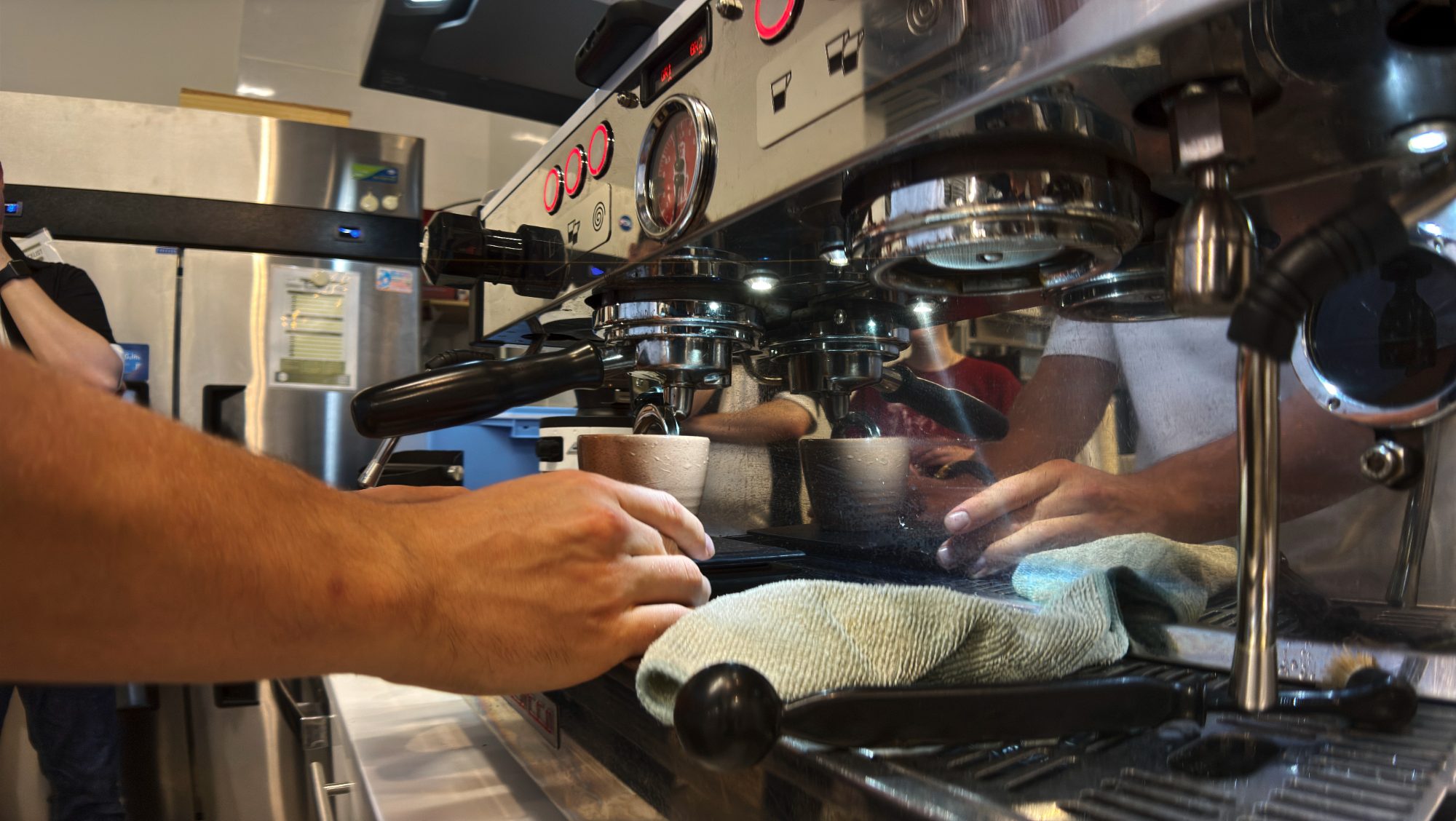 Hands working an espresso machine