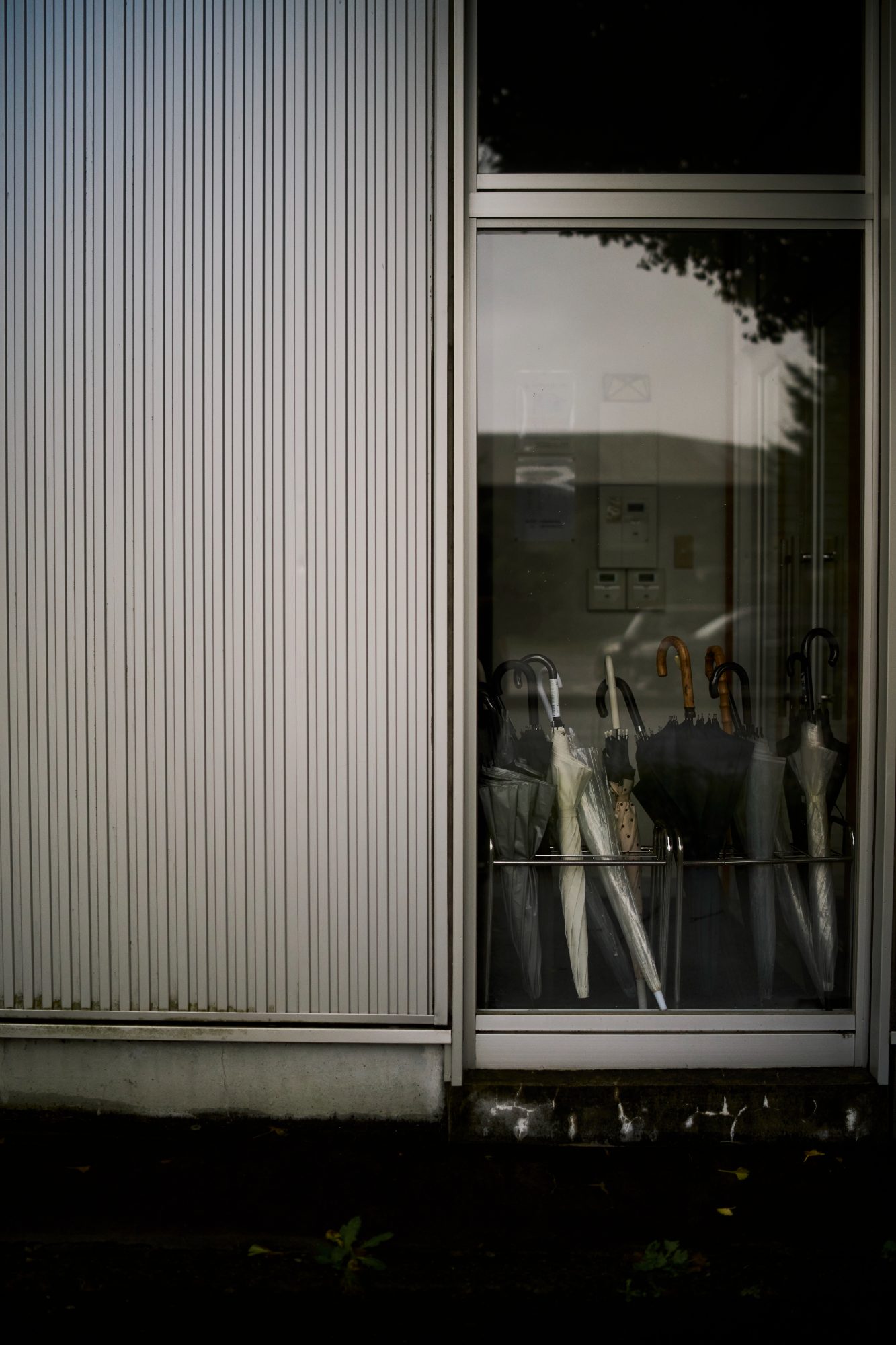 A shop window with a mannequin behind corrugated metal