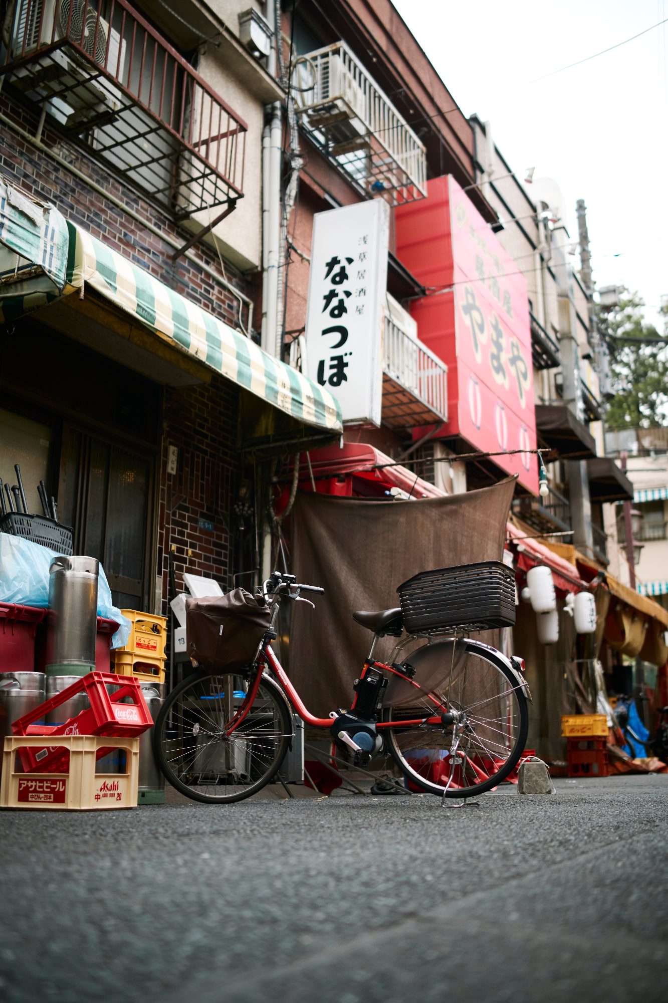 A red bicycle parked outside a shuttered shop
