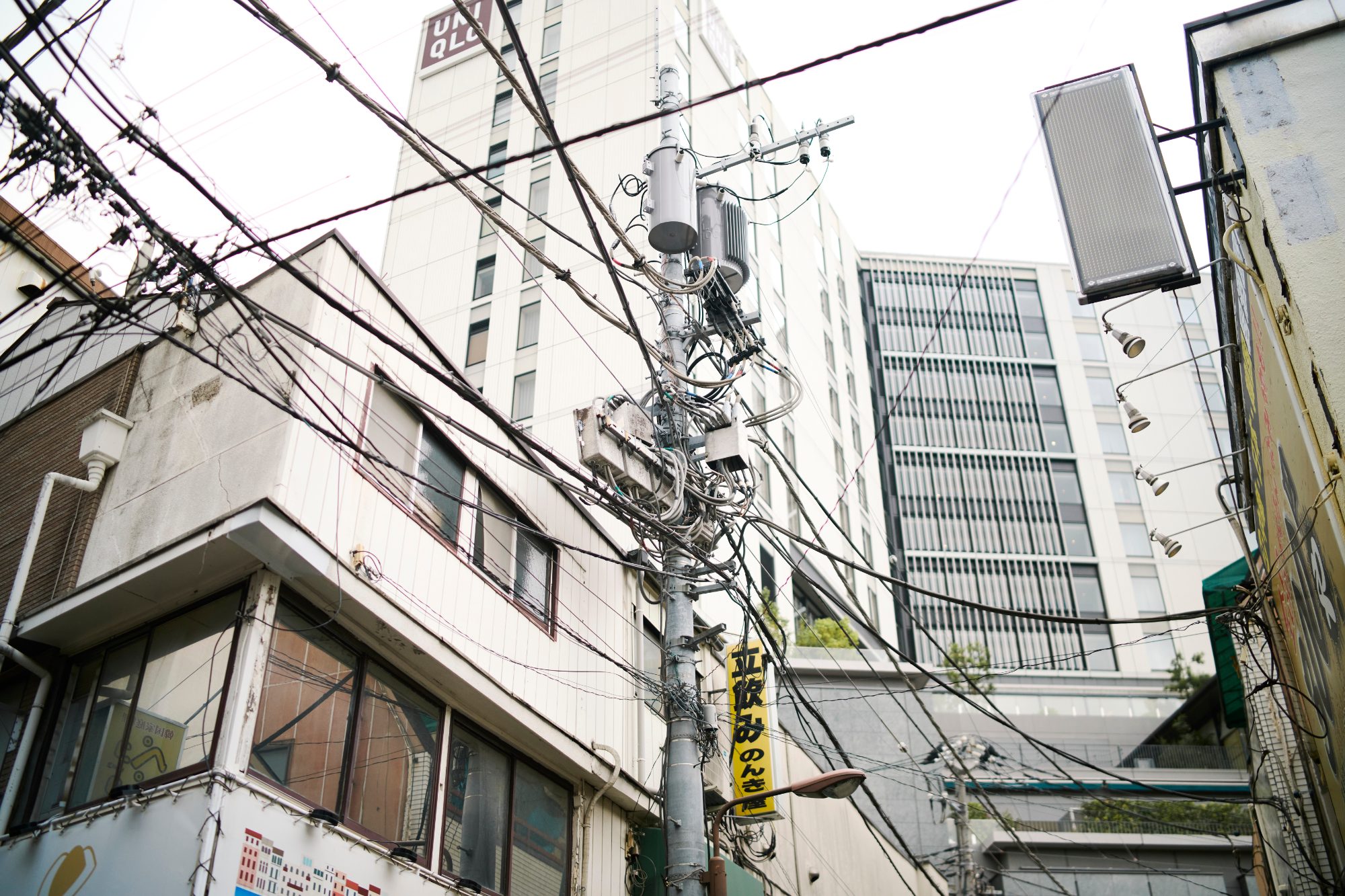 A web of power lines above concrete apartment blocks