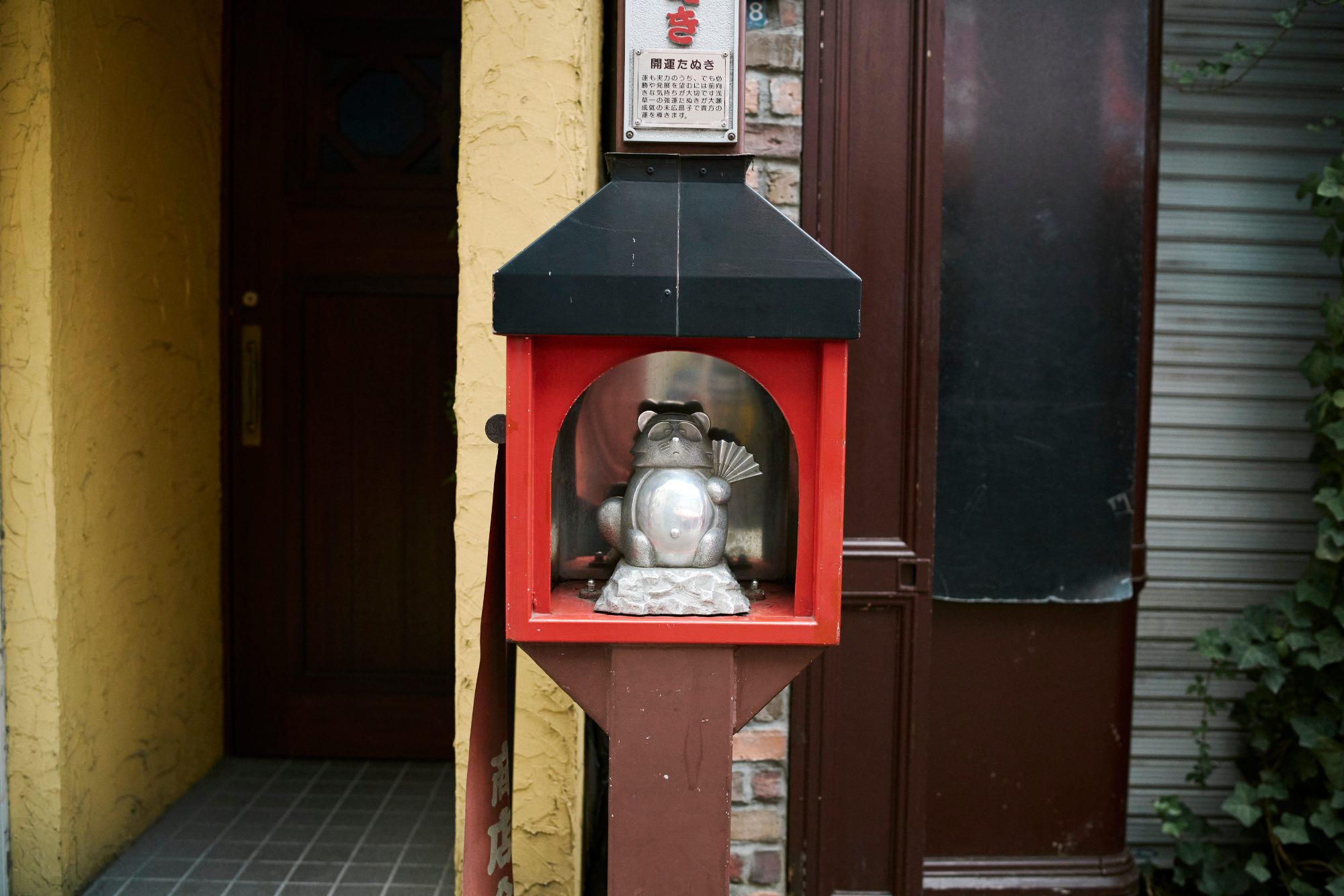 A small red shrine box set into a dark wooden wall