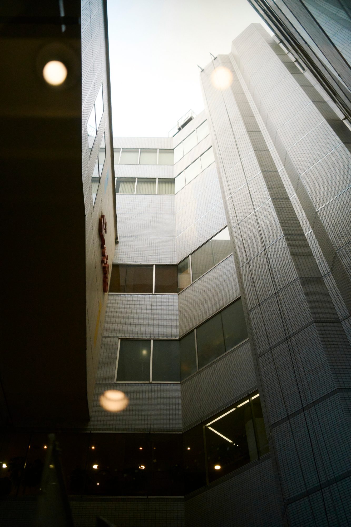 A glass building reflecting the buildings around it
