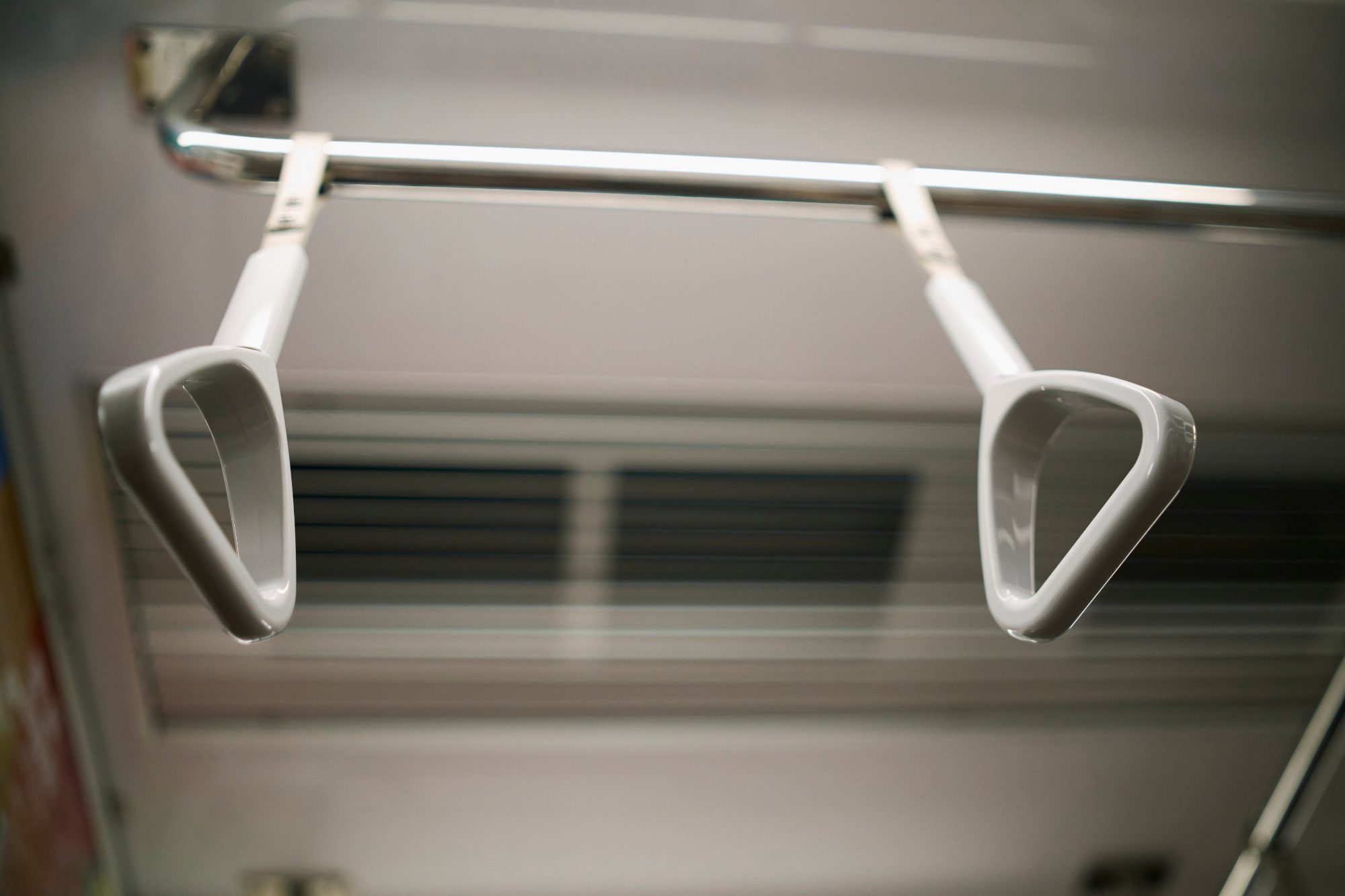Two hand straps swinging inside a train car