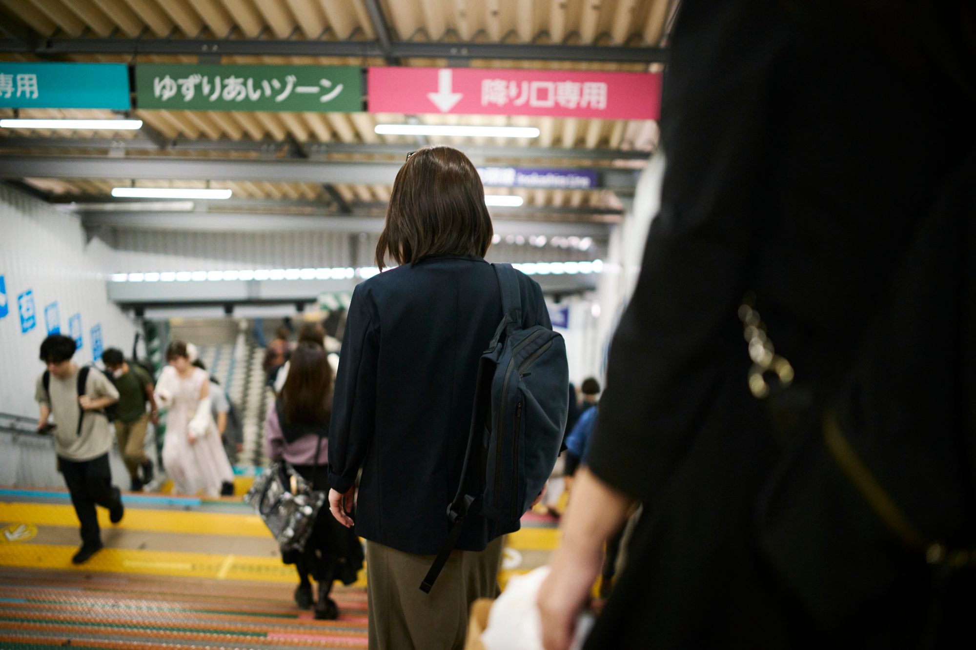 Commuters heading down a station staircase