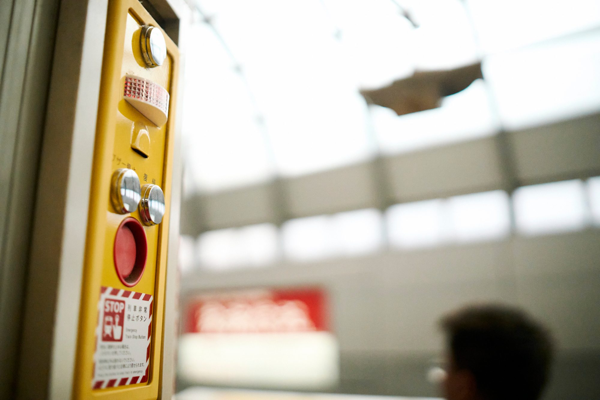 A yellow elevator call button in soft light