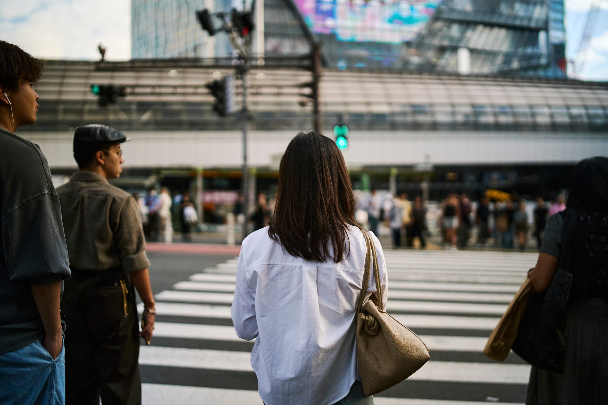People waiting at a crossing in the late afternoon sun