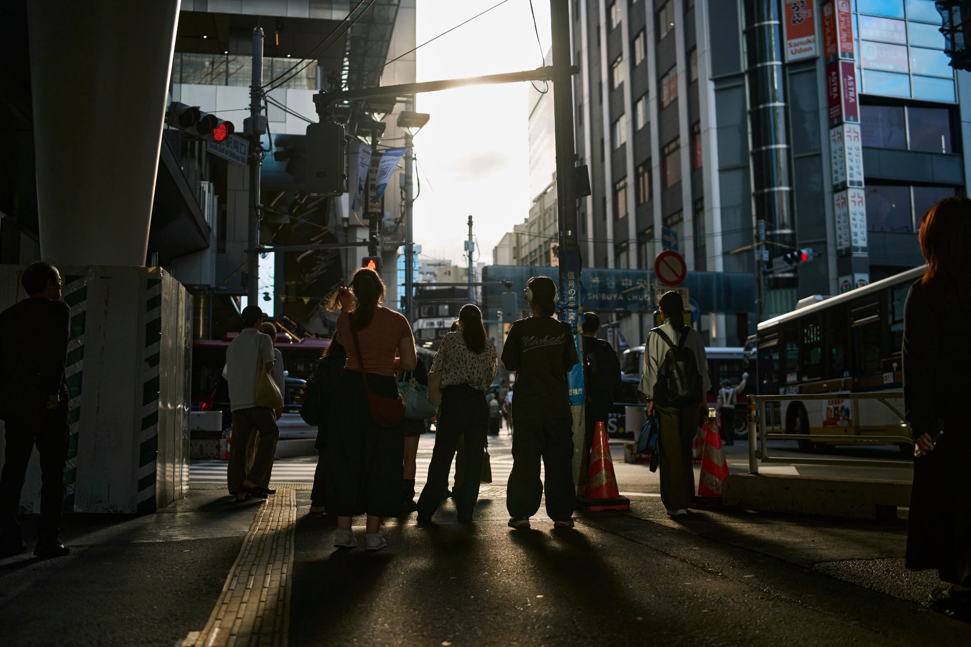 Silhouettes crossing a street into the evening sun