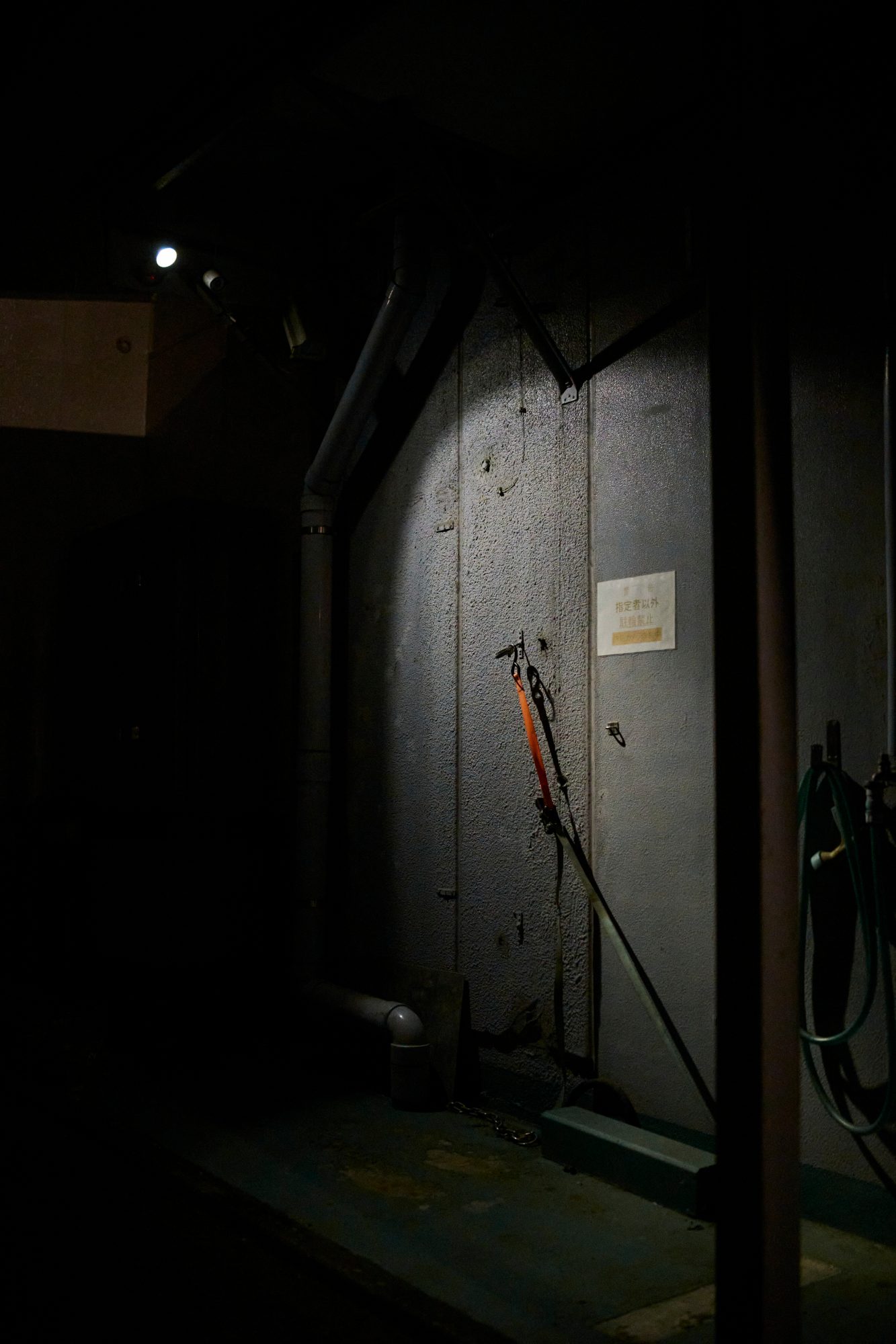 A dark doorway lit by a single lamp