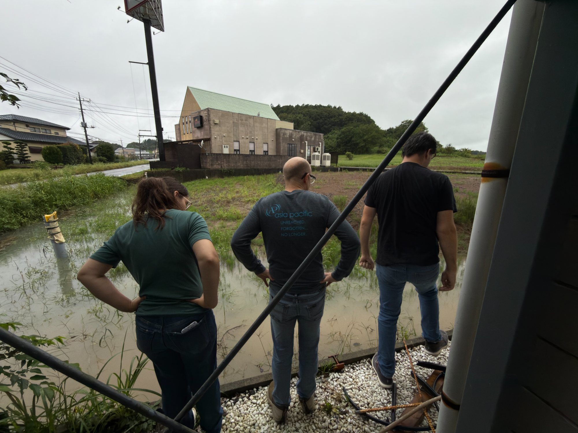 Team members looking out over a flooded field