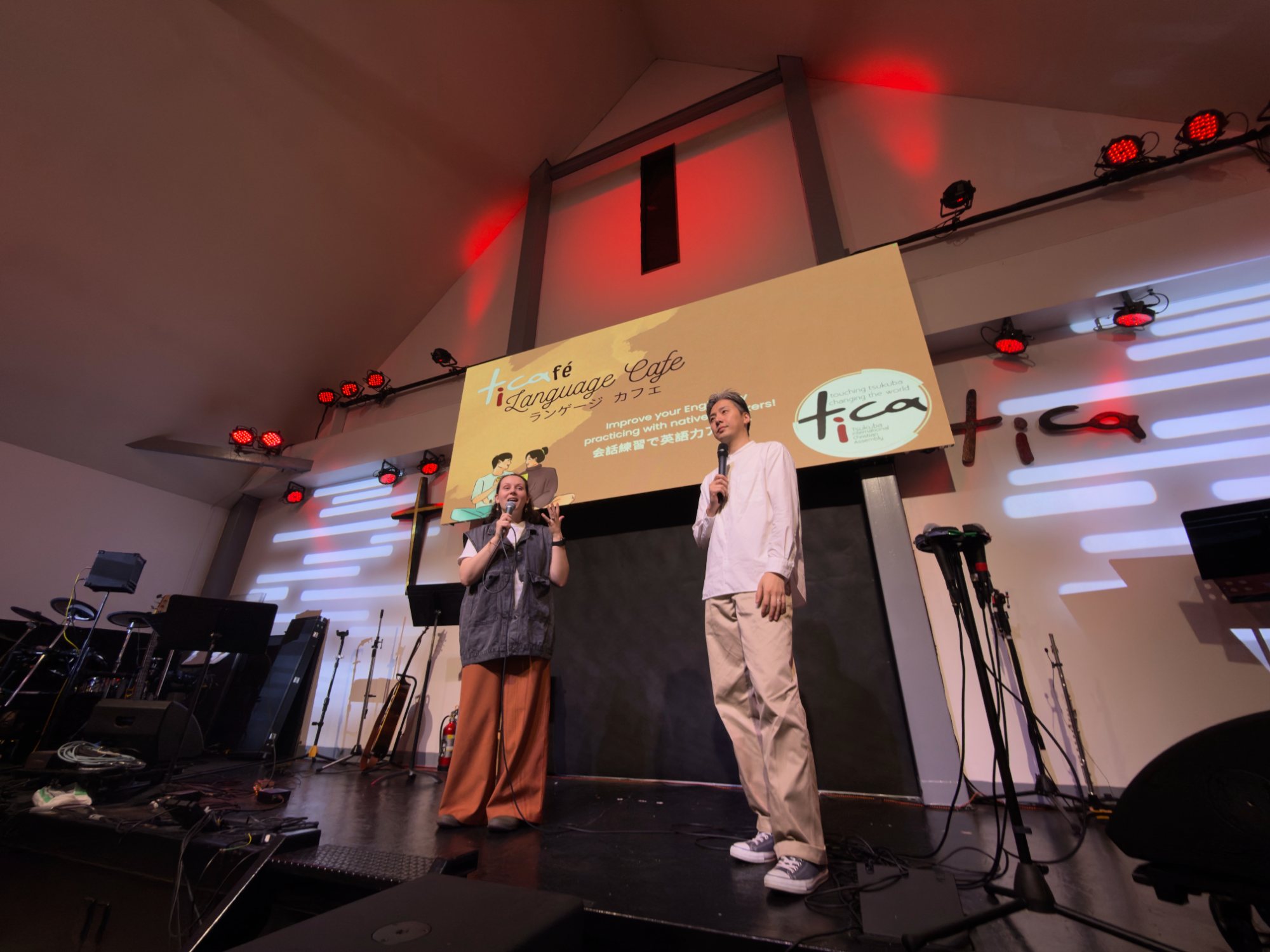 Two people speaking on stage at TICA