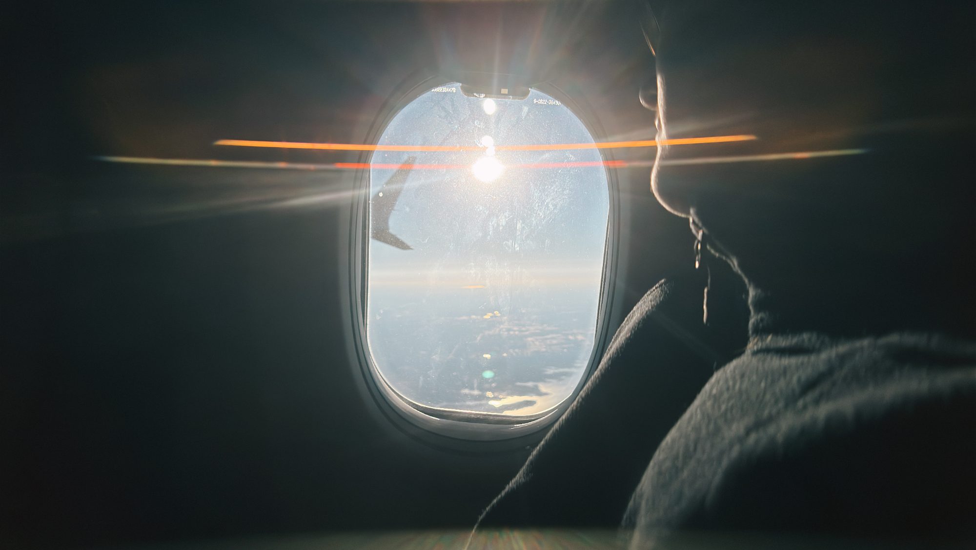 Sunlight flaring through an airplane window in flight
